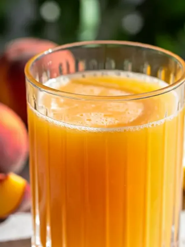 A luxurious glass of Golden Satin Elixir, glowing with a smooth golden-yellow hue, garnished with a sprinkle of turmeric and a cinnamon stick.