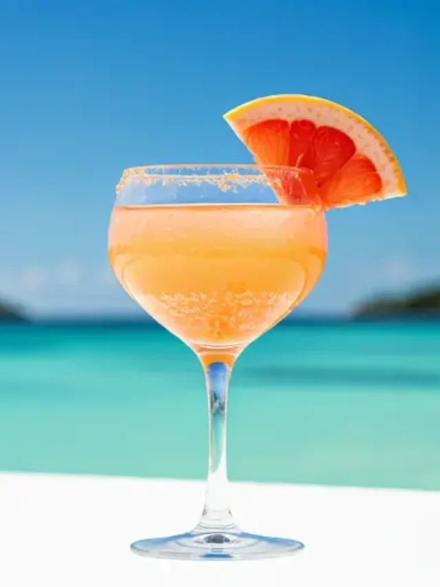 A refreshing glass of Grapefruit Detox Refresher, showcasing a soft pink hue, garnished with a slice of grapefruit and a sprig of rosemary.
