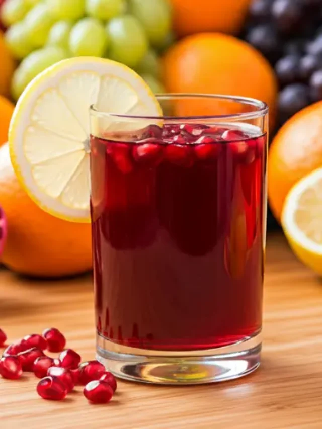 Pomegranate Paradise Elixir : A deep red pomegranate elixir in a glass, garnished with fresh pomegranate seeds and a citrus twist.