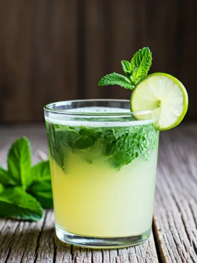 A chilled glass of Refreshing Minty Elixir for Mood Enhancement, featuring a pale green hue, garnished with fresh mint leaves and a lime wedge.