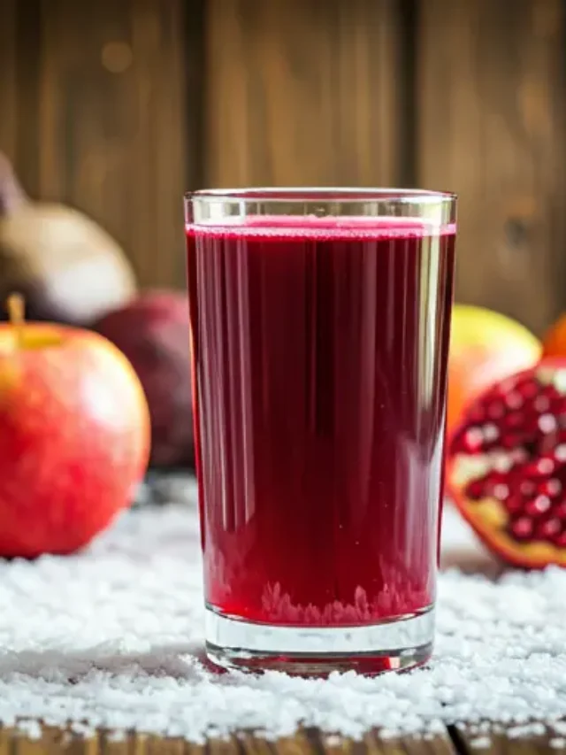 A radiant glass of Scarlet Immune Boost Elixir, showcasing a deep crimson hue, garnished with pomegranate seeds and a twist of orange peel.