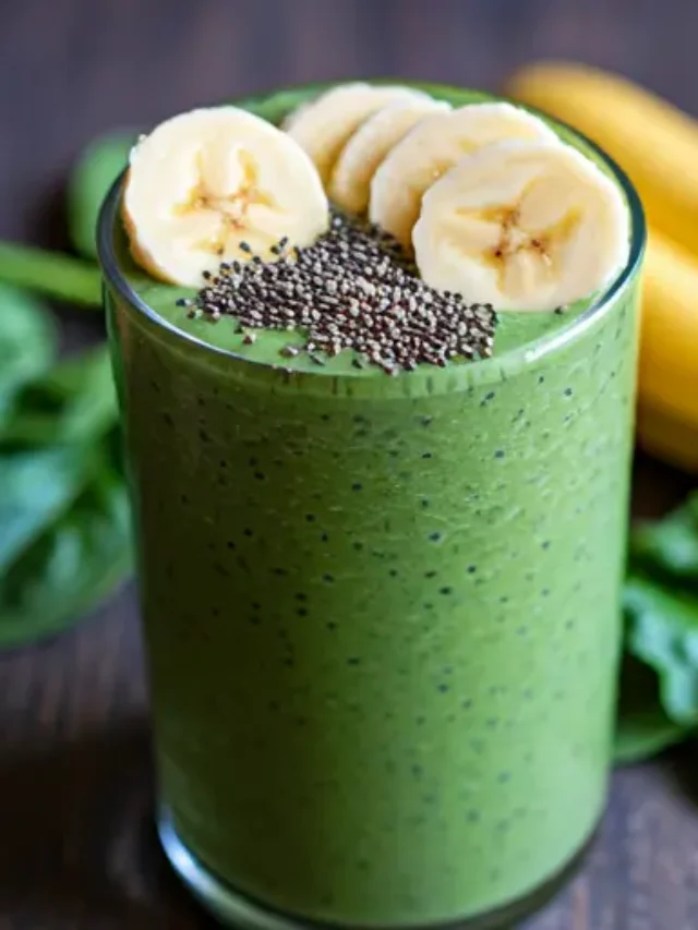 A creamy glass of Splendid Spinach Smoothie, showcasing a vibrant green color, topped with a sprinkle of chia seeds and a slice of banana.