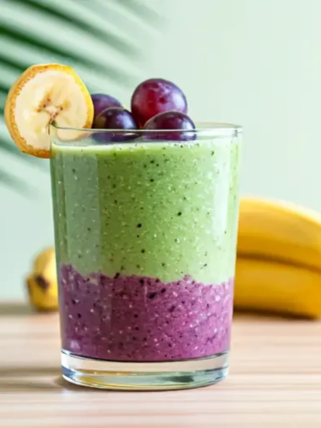 Banana Grape Smoothie Delight : A creamy yellow-orange smoothie in a glass, garnished with a banana slice and an orange wedge, exuding a vibrant and refreshing appeal.