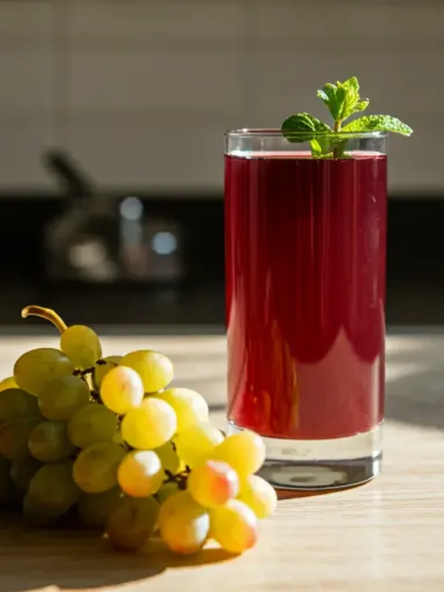 Crimson Harmony Grape Juice : A rich, deep red grape juice in a glass, garnished with a cluster of fresh grapes and a sprig of mint, radiating natural sweetness.
