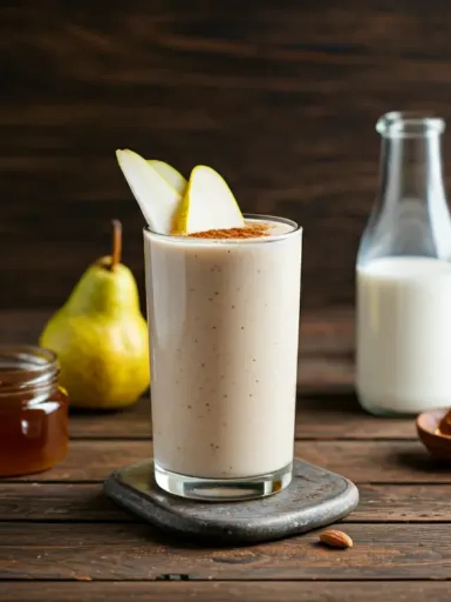Creamy Pear Smoothie : A creamy pear smoothie in a glass, garnished with a pear slice and a sprinkle of cinnamon.
